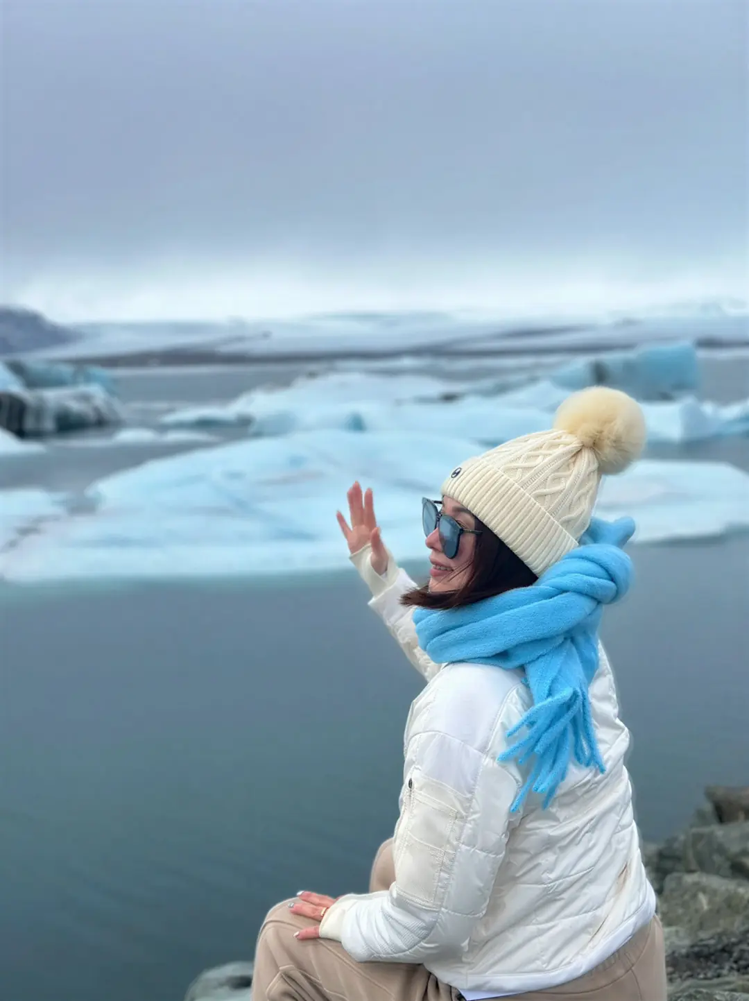 Alicia Dai in winter white at an Icelandic glacier lagoon