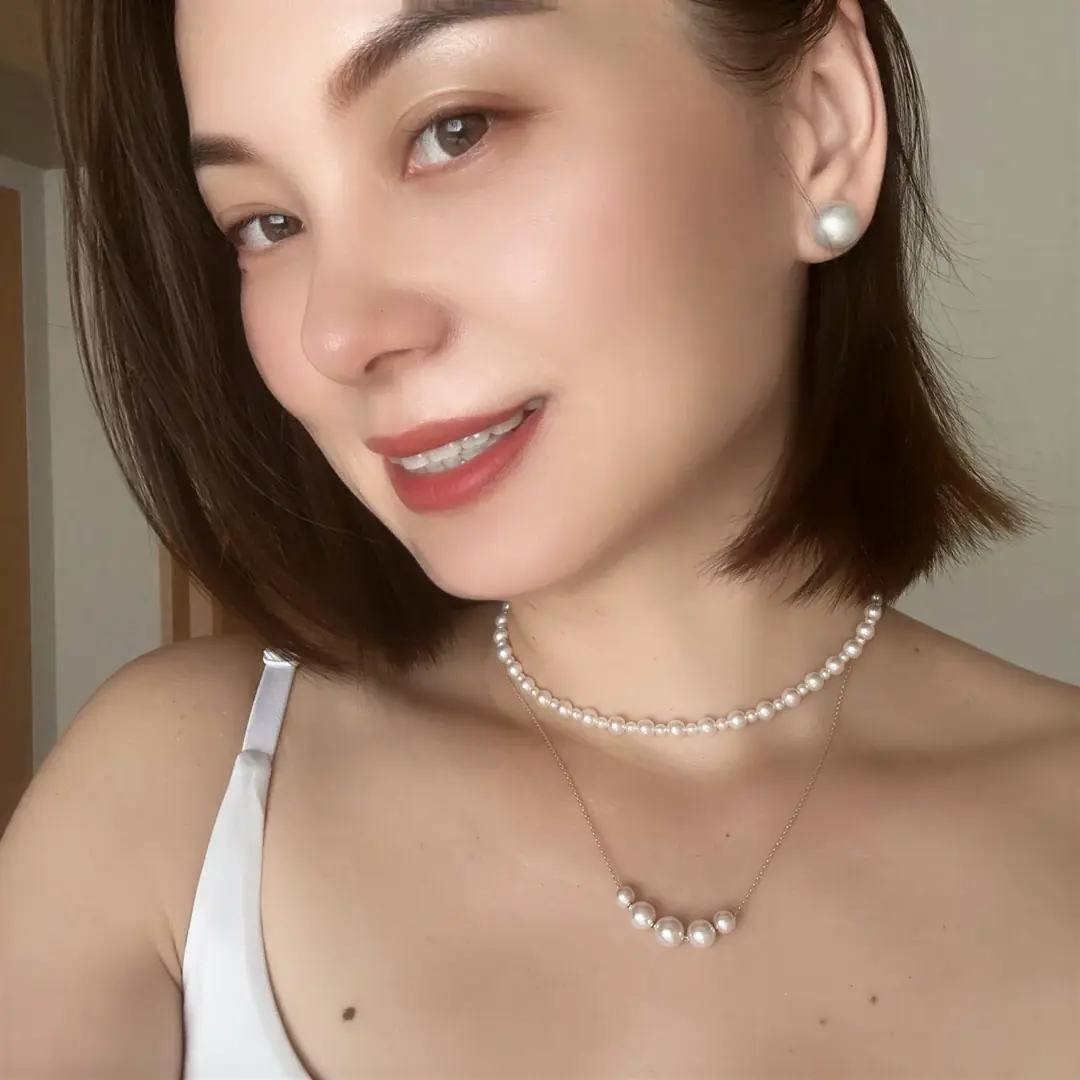 Close portrait of Alicia Dai wearing layered pearl necklaces