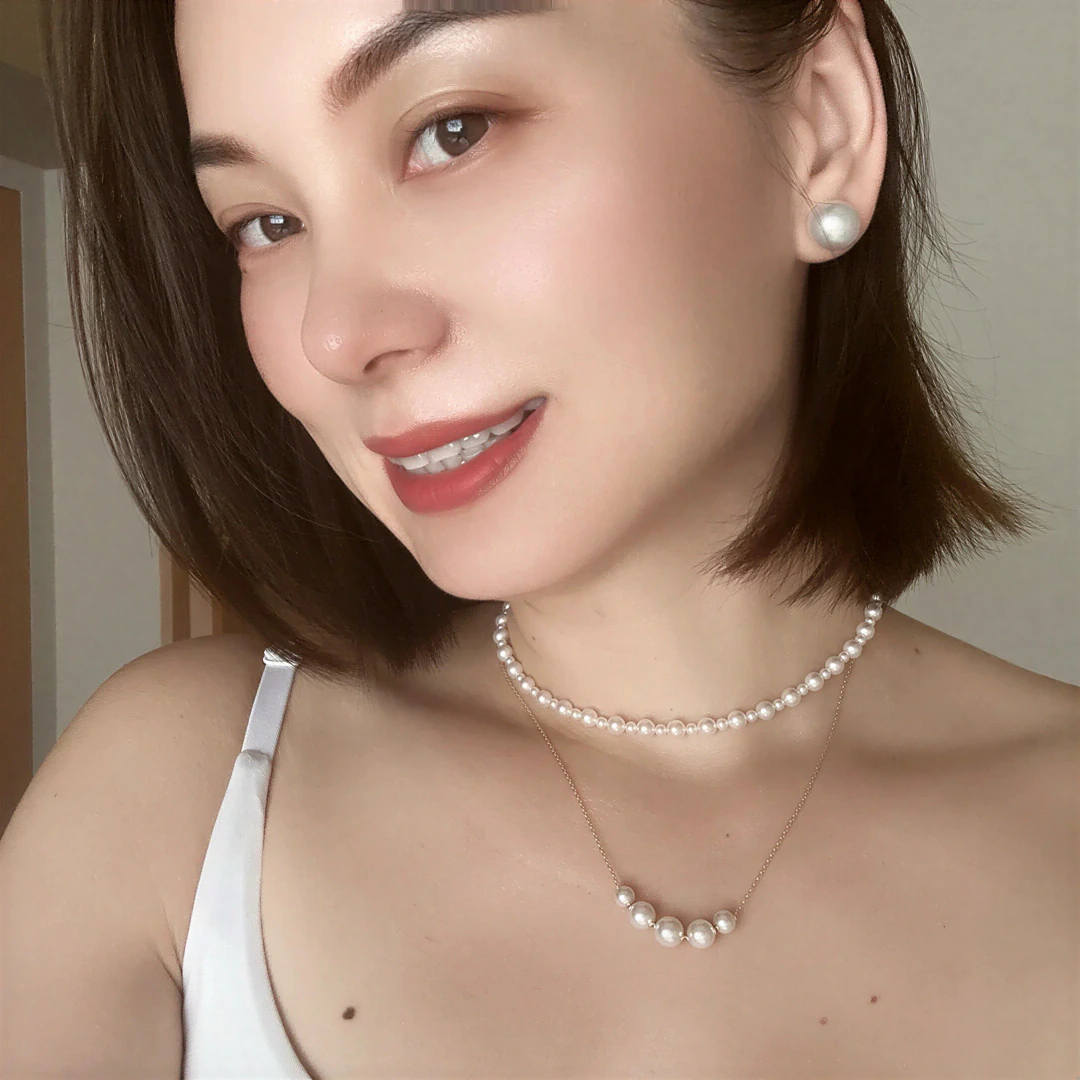 Close portrait of Alicia Dai wearing layered pearl necklaces