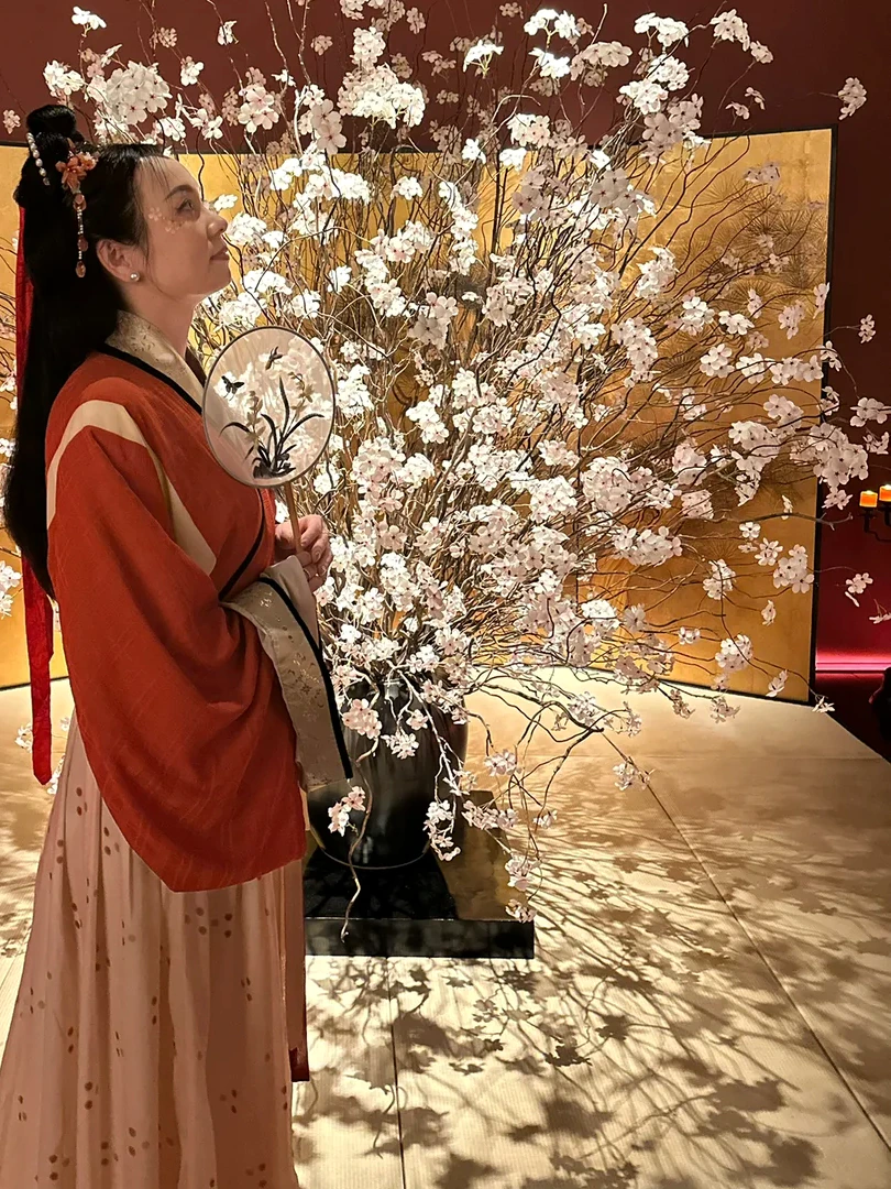Alicia Dai in vermilion Song-dynasty styling among white blossoms