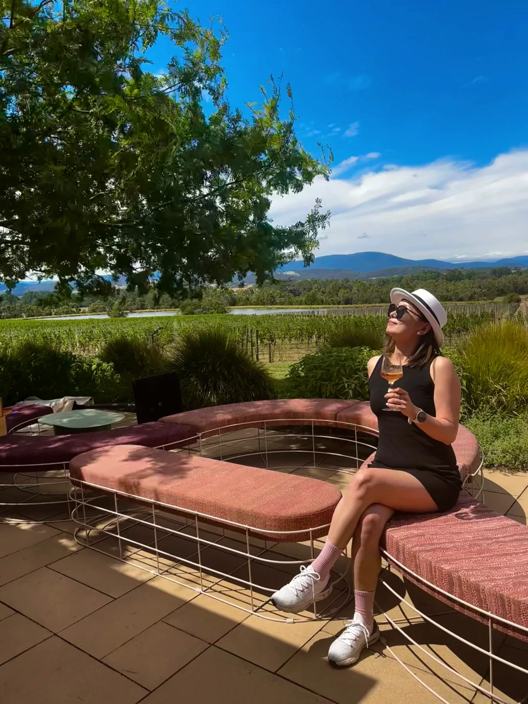 Alicia Dai in a black dress and white hat in the Yarra Valley